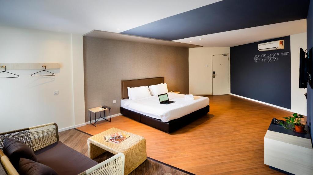 um quarto de hotel com uma cama e uma sala de estar em H Boutique Hotel Xplorer Cheras em Kuala Lumpur