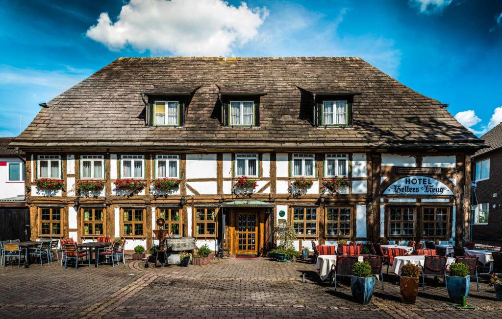 an old building with tables and chairs in front of it at Hotel Hellers Krug in Holzminden