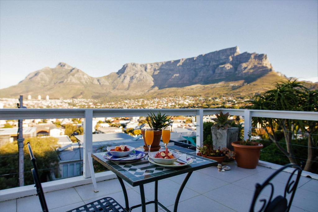 a table on a balcony with a view of mountains at Radium Hall Guest House in Cape Town