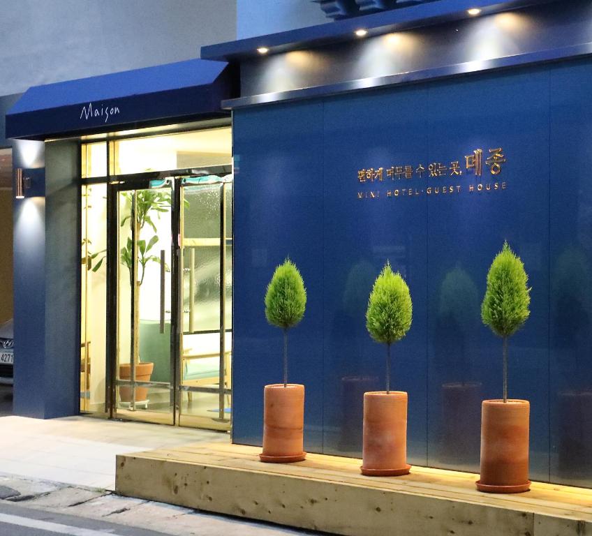 un edificio blu con tre alberi davanti di Maison Mini Hotel a Gyeongju
