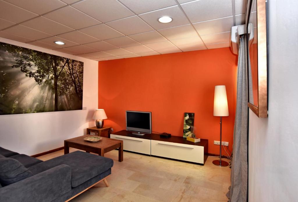 een woonkamer met een bank en een tv bij City Living Suite TK 2 Rm 3. in St Julian's