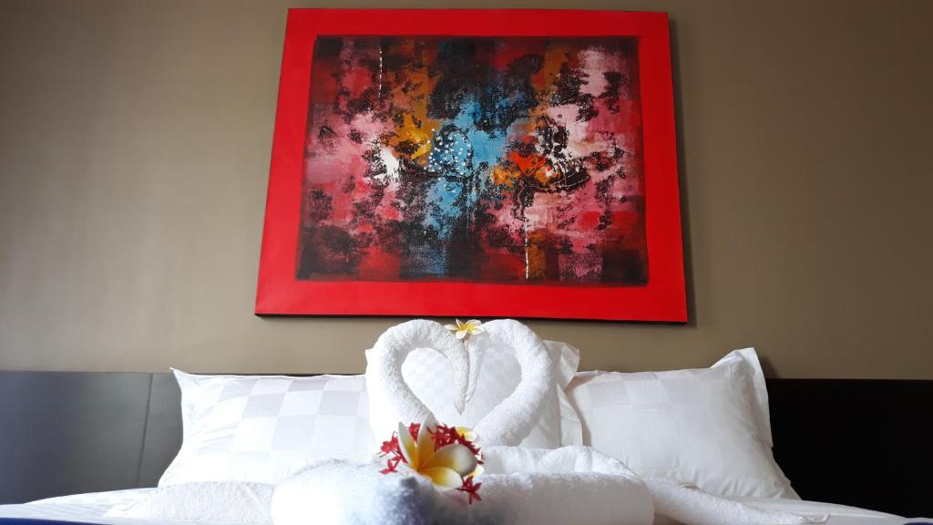łabędź zrobiony z ręczników siedzący na łóżku w obiekcie Asiana Lovina Hotel w mieście Lovina