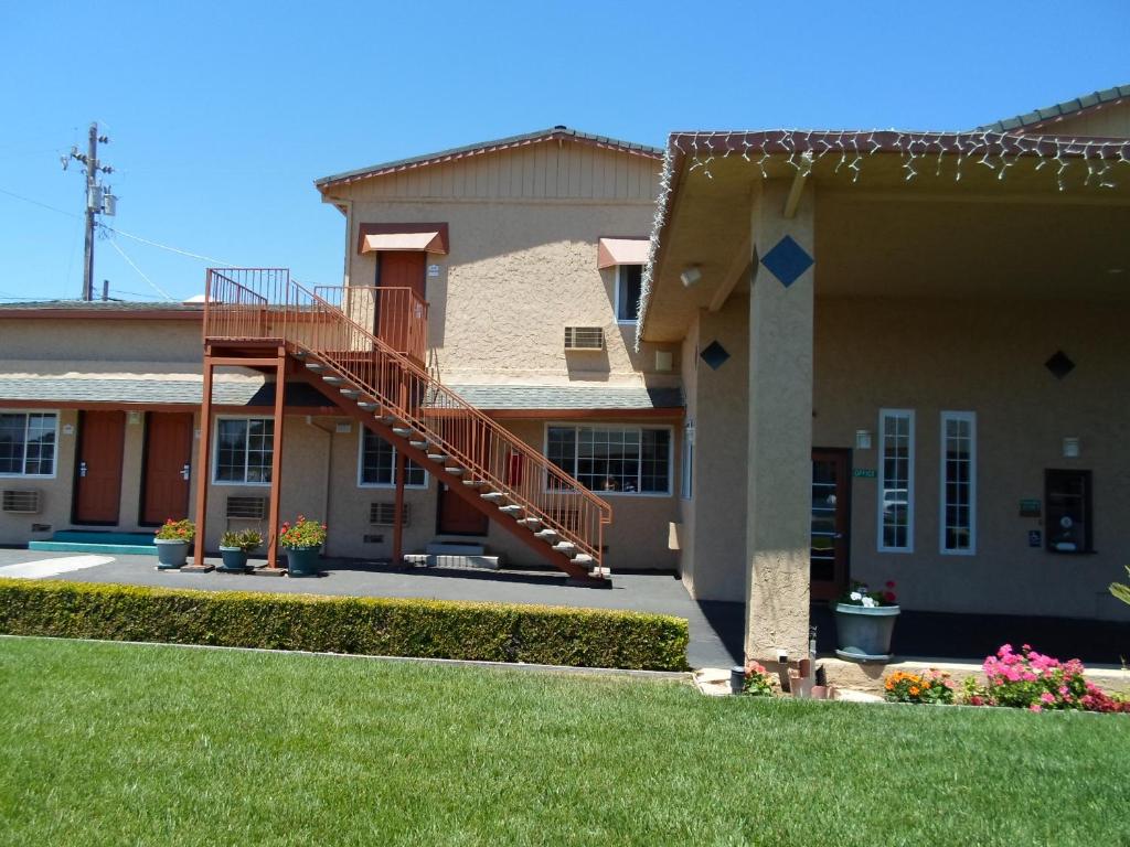 a house with a staircase on the side of it at Economy Inn Morgan Hill in Morgan Hill