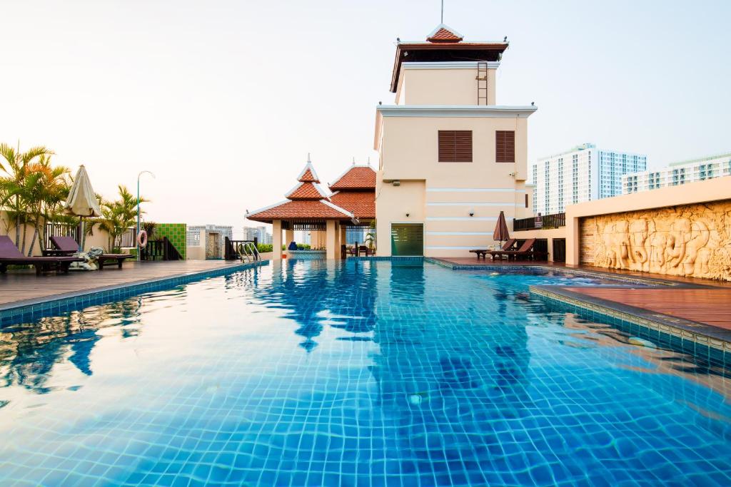 una piscina frente a un edificio con un faro en Aiyara Palace, en Norte de Pattaya