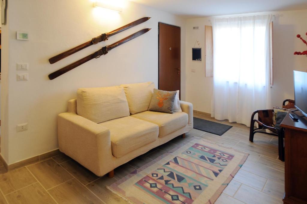 uma sala de estar com um sofá e uma televisão em Casa Polsa "1964" em Brentonico