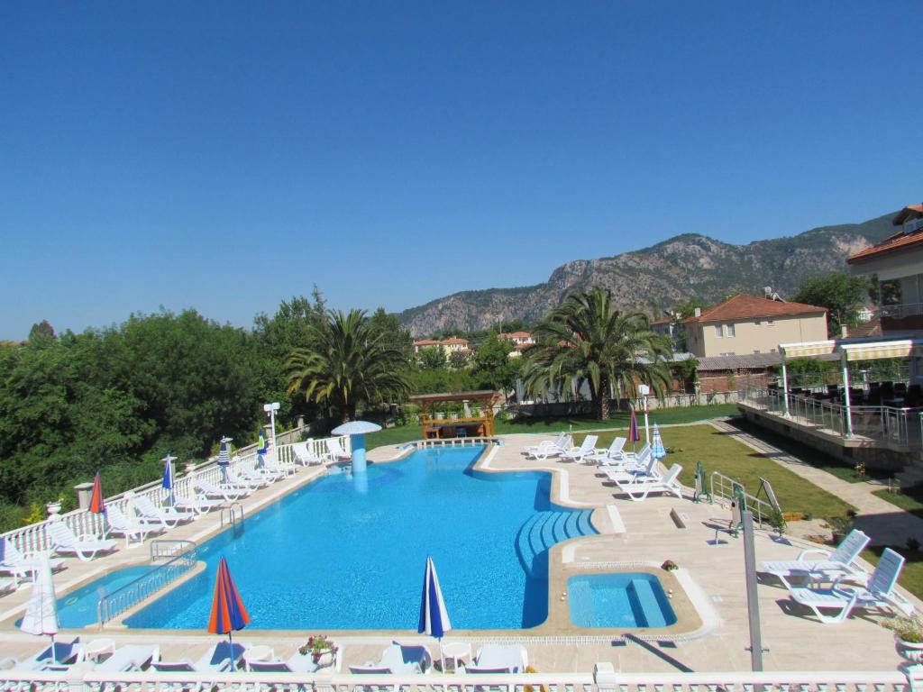 a large swimming pool with lounge chairs and a resort at Dalyan Palmiye Resort Hotel in Dalyan