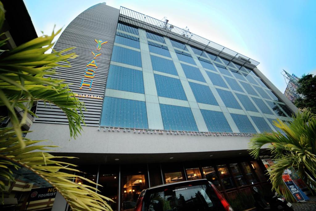 a building with blue windows and a car parked in front at YASH INTERNATIONAL in Kozhikode