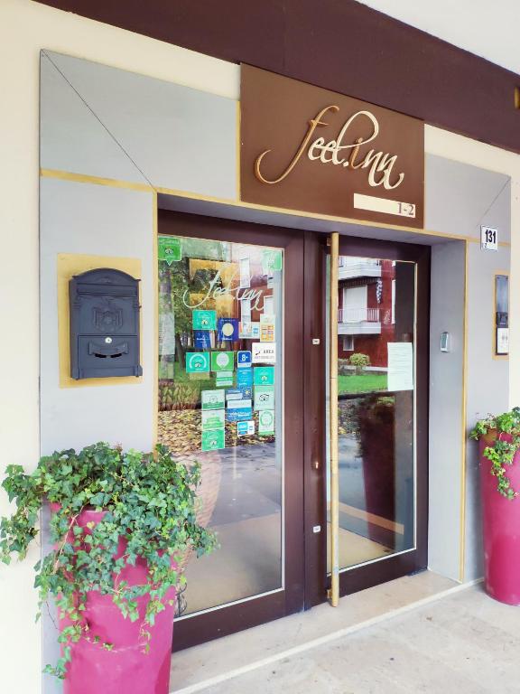 ein Schaufenster mit zwei Topfpflanzen davor in der Unterkunft Hotel Feel Inn Venice Airport in Campalto