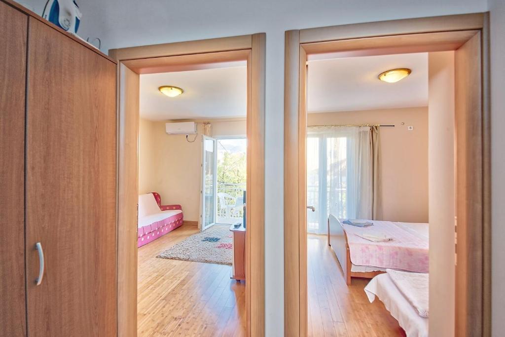赫爾採格諾維的住宿－Apartments LUX Milano, Savina,Herceg-Novi，卧室设有一扇门,可通往带一张床的房间