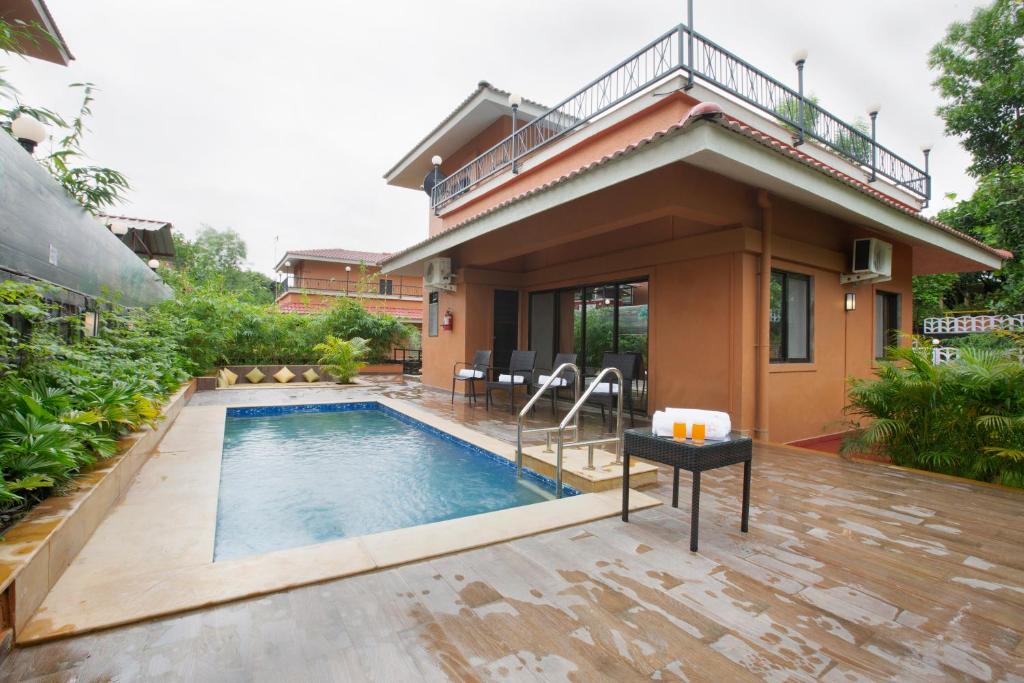 a house with a swimming pool in the backyard at SaffronStays Dhyana, Vikramgad in Pālghar