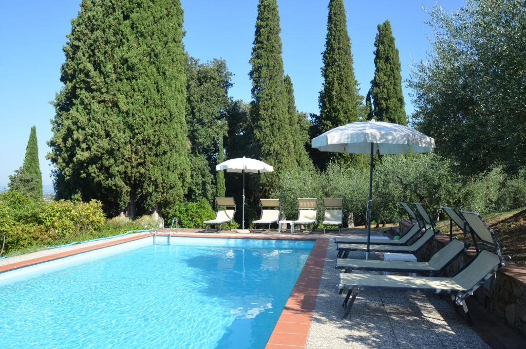 uma piscina com espreguiçadeiras e um guarda-sol em Casa Cesira em Arezzo