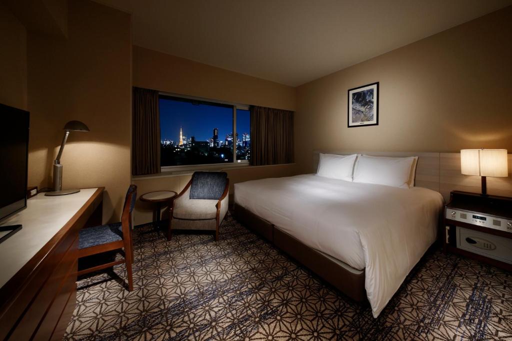 a hotel room with a bed and a desk and a window at Grand Prince Hotel Takanawa in Tokyo