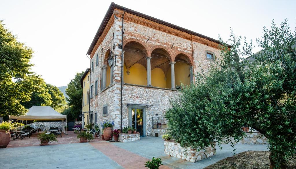 un viejo edificio de ladrillo con una tienda delante en Hotel Villa Rinascimento, en Lucca
