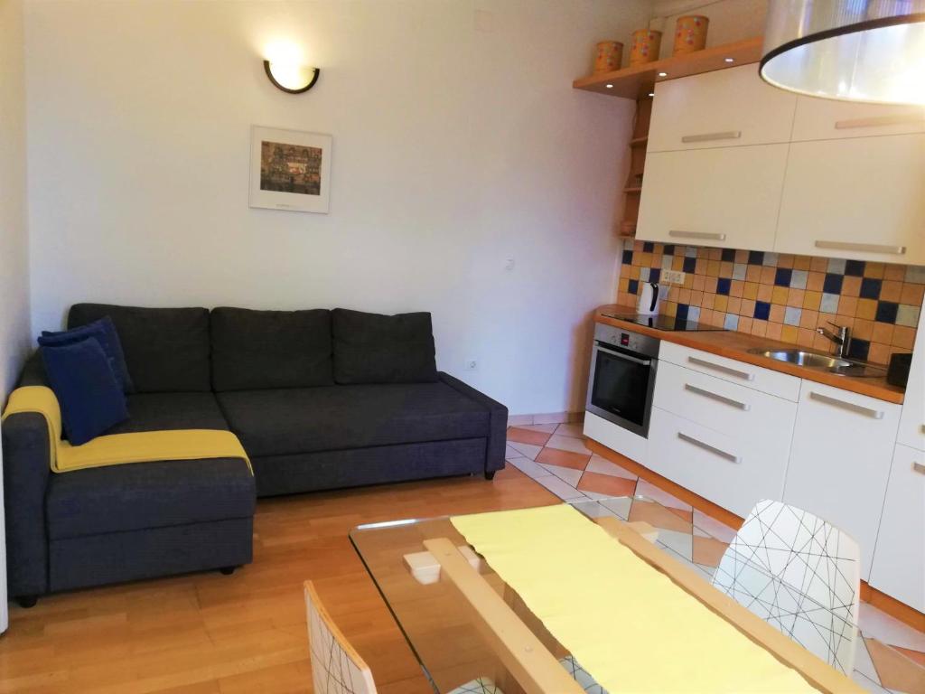 uma sala de estar com um sofá e uma mesa em Dimora Apartments with free parking em Ljubljana