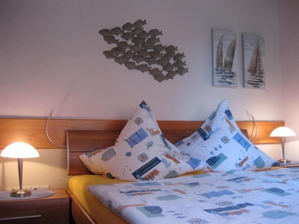 1 dormitorio con 1 cama con almohadas y 2 lámparas en Fewo Kroker, en Bremerhaven