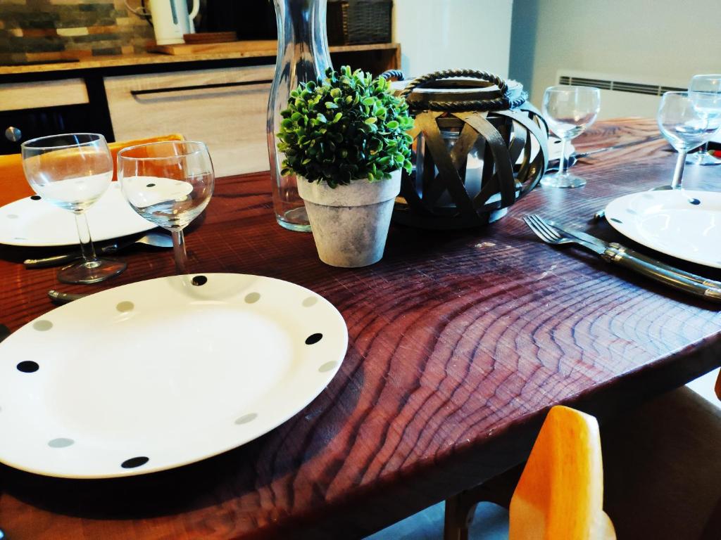 une table en bois avec une plaque et une plante sur celle-ci dans l'établissement Maison de Louna, à La Bourboule