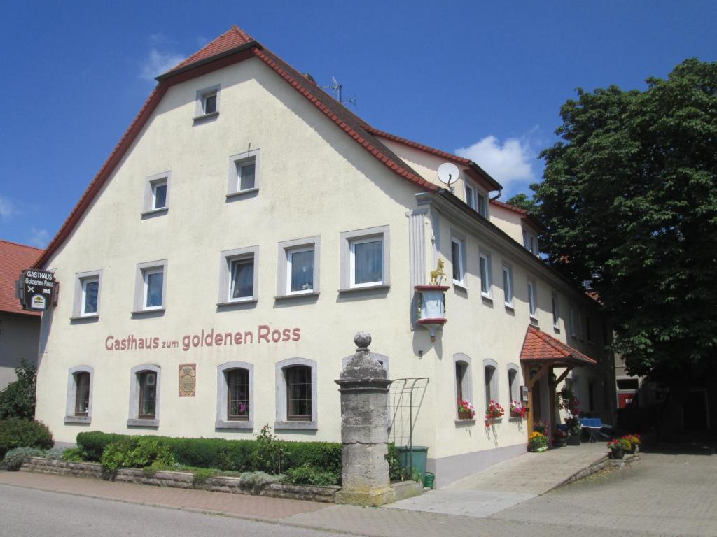 een wit gebouw aan de straatkant bij Gasthaus zum Goldenen Roß in Creglingen