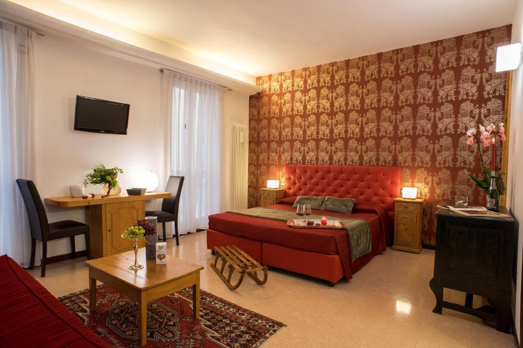 a bedroom with a red bed and a living room at Relais La Torre in Verona