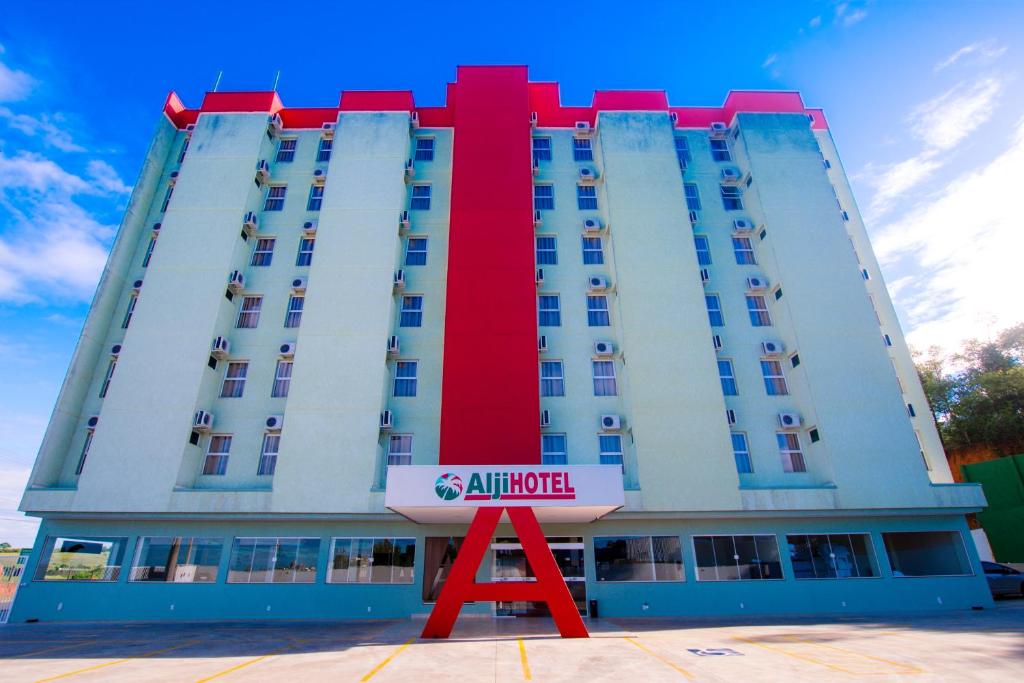 a large hotel with a red and white building at Hotel Alji Salto in Salto