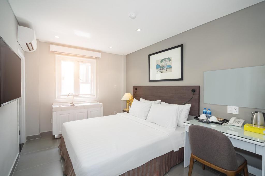 a hotel room with a bed and a desk at Park Hill Hotel - Phu My Hung in Ho Chi Minh City