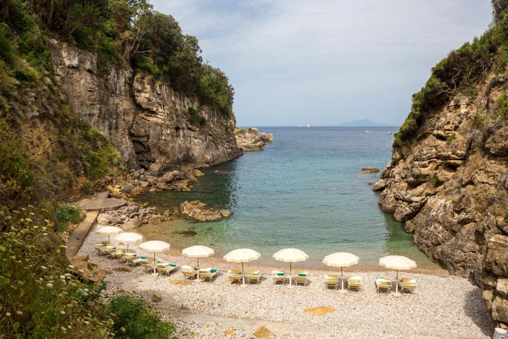 ein Strand mit Sonnenschirmen und Stühlen und das Meer in der Unterkunft Relais Regina Giovanna in Sorrent