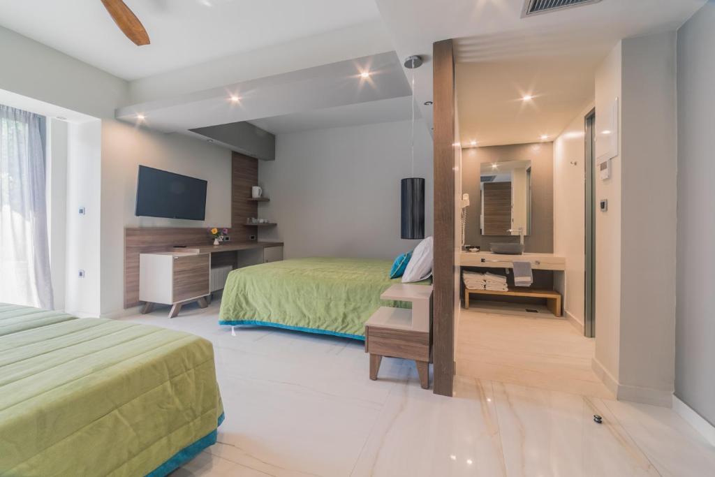 a bedroom with a bed and a desk and a television at Atrion Resort Hotel in Agia Marina Nea Kydonias
