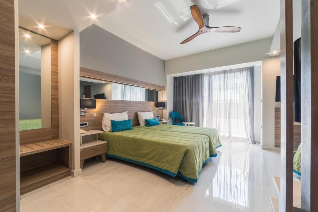a bedroom with a bed and a large window at Atrion Resort Hotel in Agia Marina Nea Kydonias