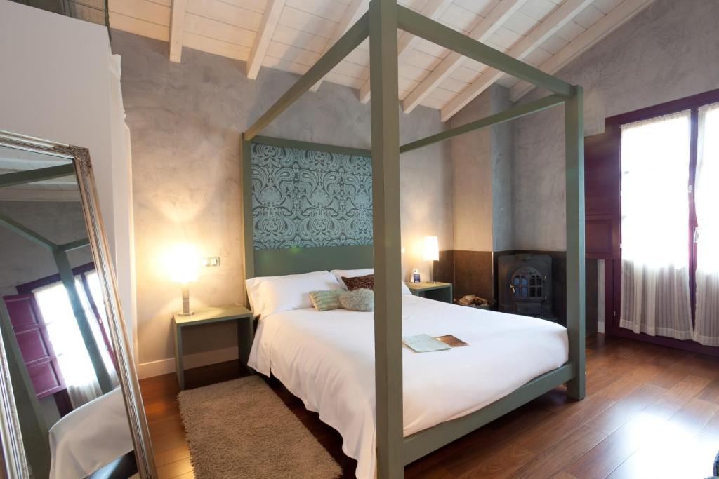 een slaapkamer met een groot bed met een groen hoofdeinde bij Casa Rural Etxegorri in Murueta-Orozko
