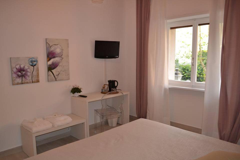 Un dormitorio blanco con una cama y una ventana. en Le camere del Corso, en San Remo