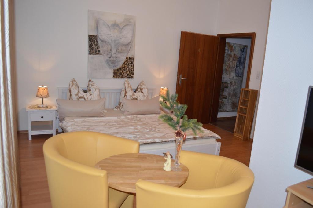 a living room with a table and yellow chairs at Ulrike's Pension am Kurpark in Bad Sooden-Allendorf