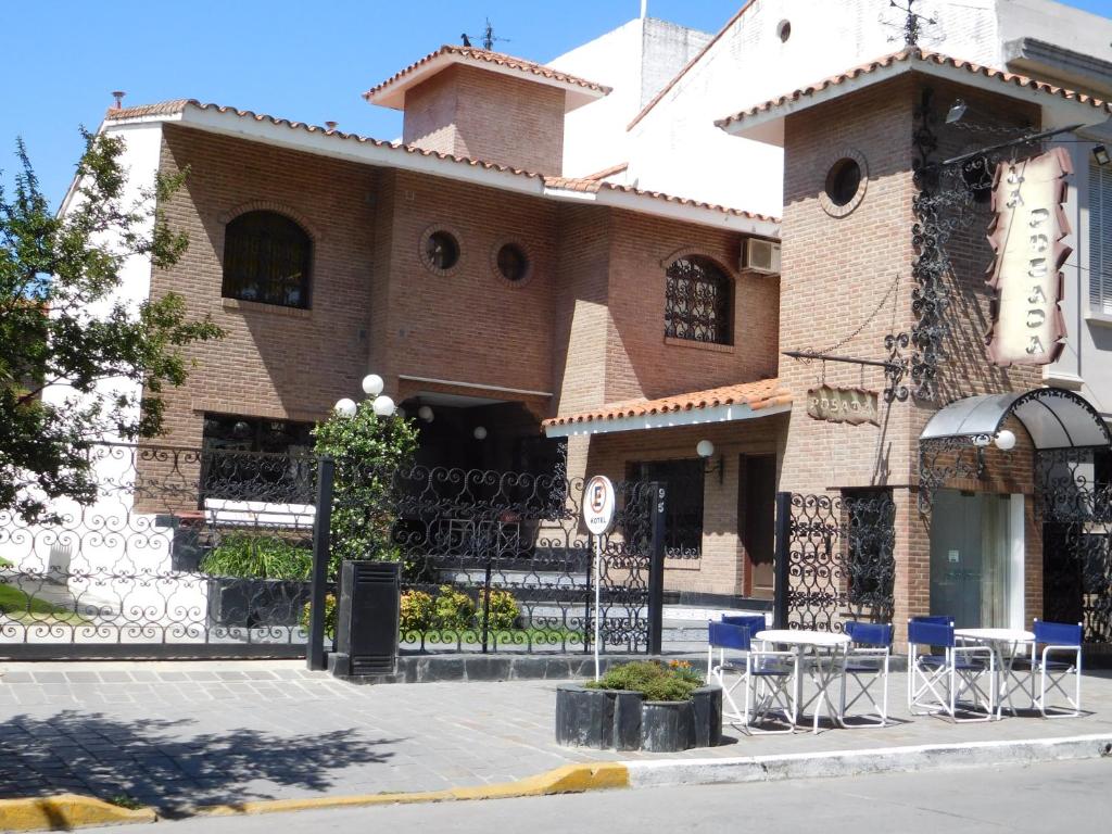 un edificio con sillas azules delante de él en La Posada en Alta Gracia