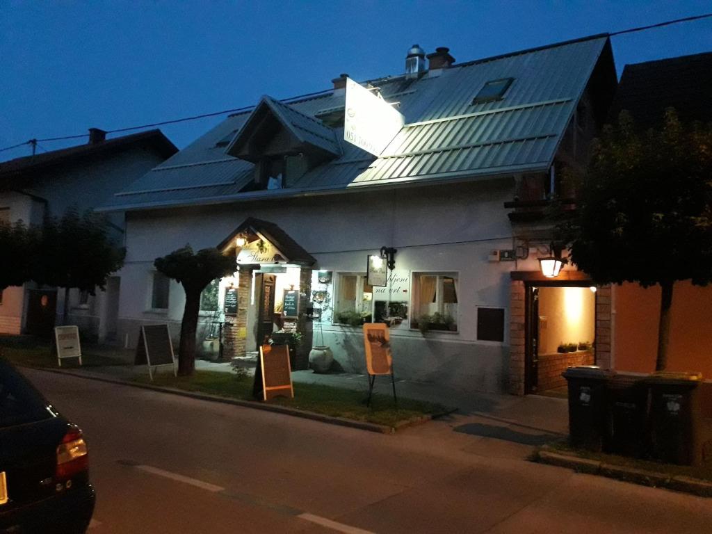 una gran casa blanca con carteles delante en Hostel Piero en Liubliana