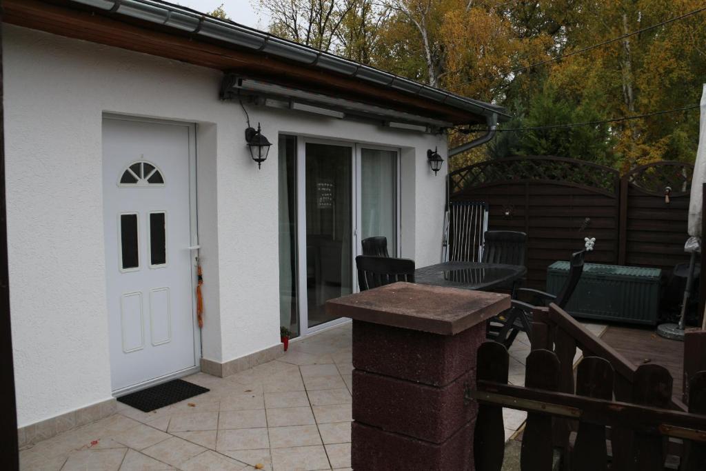 a white house with a white door and a patio at Ferienwohnung am Schwielochsee in Schwielochsee