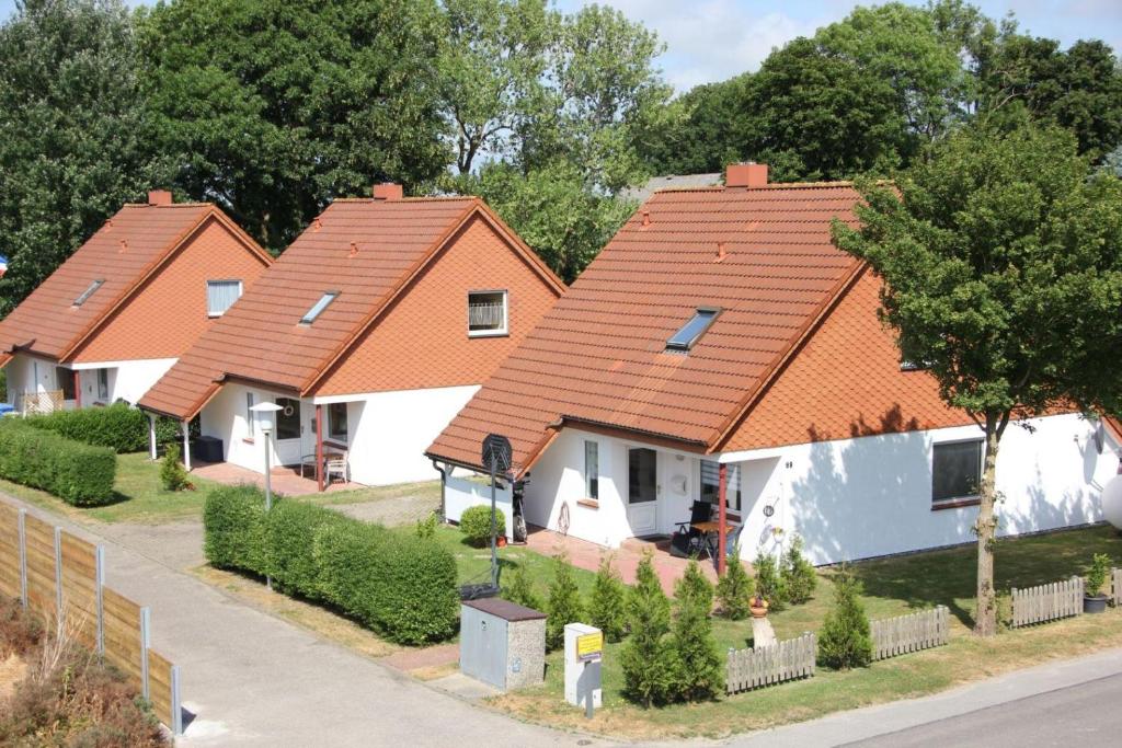 a row of houses with orange roofs on a street at GoWatt in Friedrichskoog