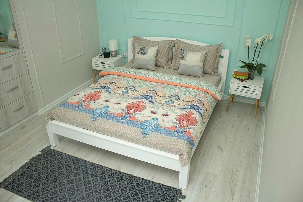 een kleine slaapkamer met een bed met een blauwe muur bij вулиця Лемківська in Lviv
