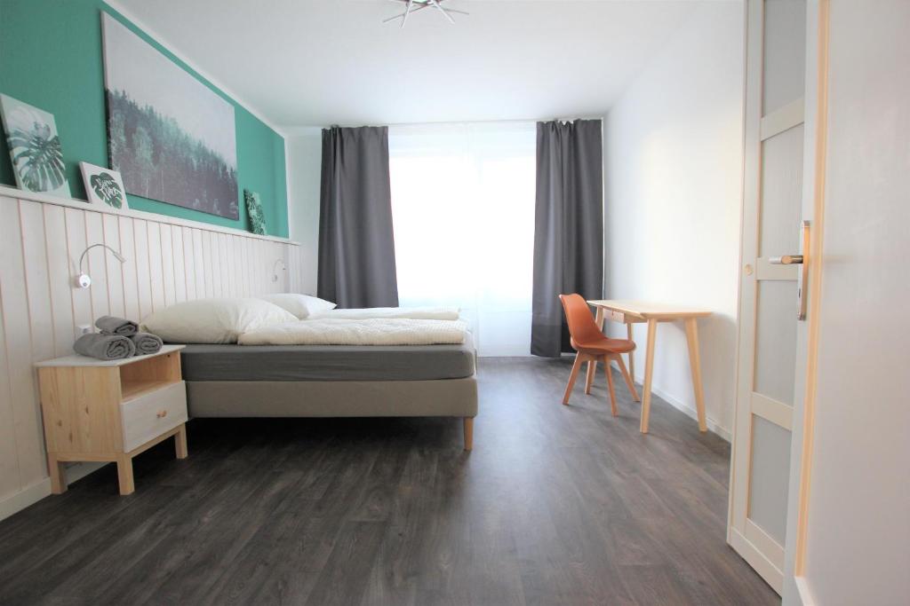a bedroom with a bed and a desk and a table at Centrally located 2-room apartment in Hannover