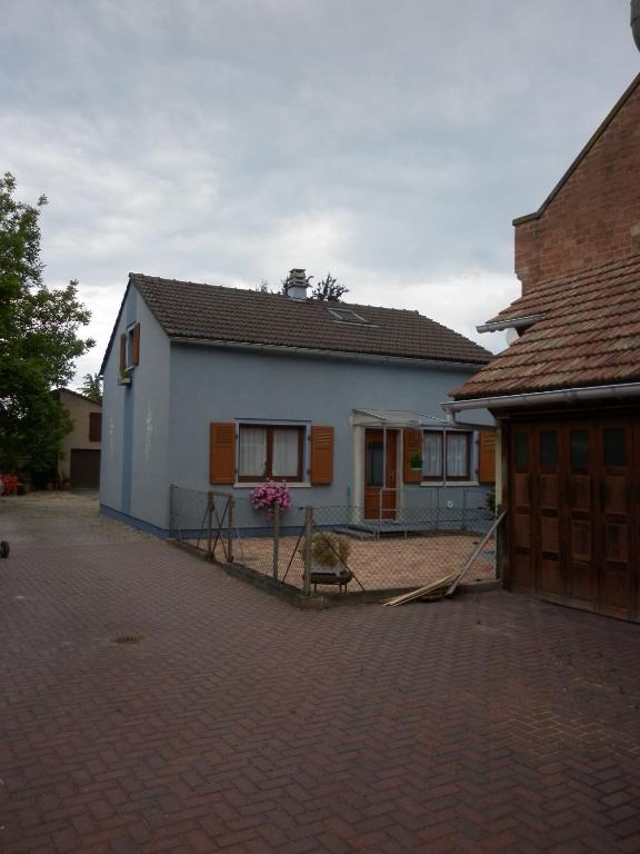 une maison blanche avec une clôture devant dans l'établissement Maison bleue Petermann, à Marckolsheim