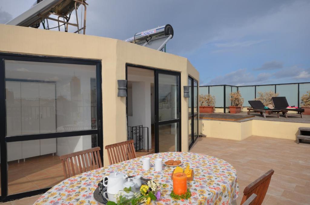 a table on the balcony of a house at City Living Suite Tk 3 Rm 1 in St Julian's