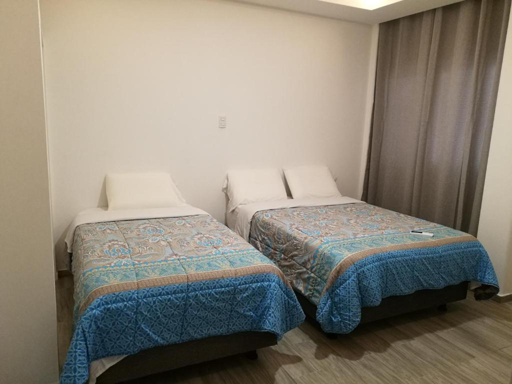 Postel nebo postele na pokoji v ubytování DC Suites Aeropuerto