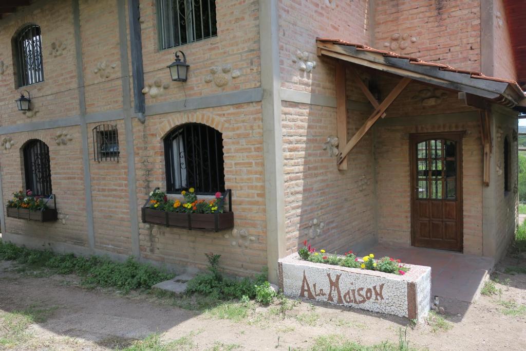 un bâtiment en briques avec deux boîtes de fleurs sur lui dans l'établissement Cabañas A la Maison, à Mina Clavero