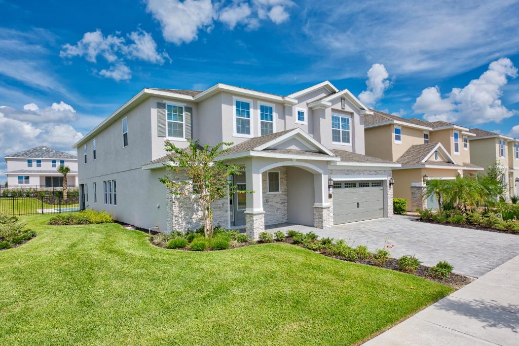 Casa grande con entrada y césped en Gorgeous Home with Loft Area & Themed Rooms near Disney by Rentyl - 7687F, en Orlando