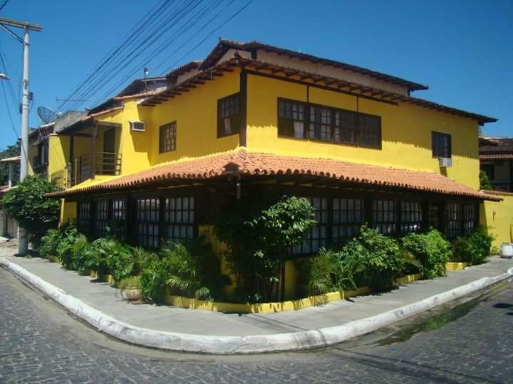um edifício amarelo no lado de uma rua em Axé Brasil em Búzios
