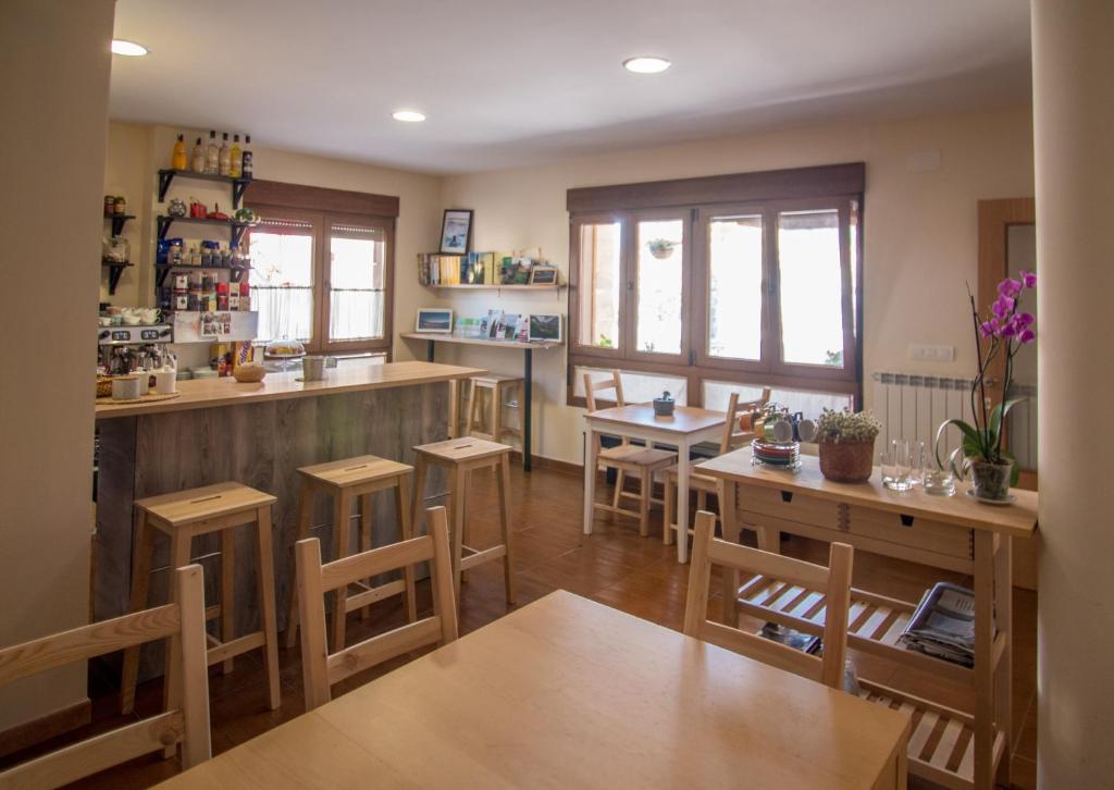 a kitchen with wooden tables and chairs and a bar at Albergue de Prioro in Prioro