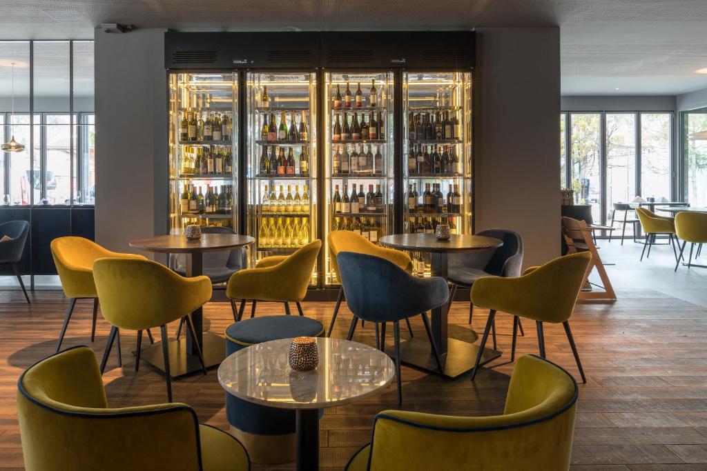 un ristorante con tavoli, sedie e scaffali di bottiglie di vino di Eden Hotel und Restaurant a Ilanz