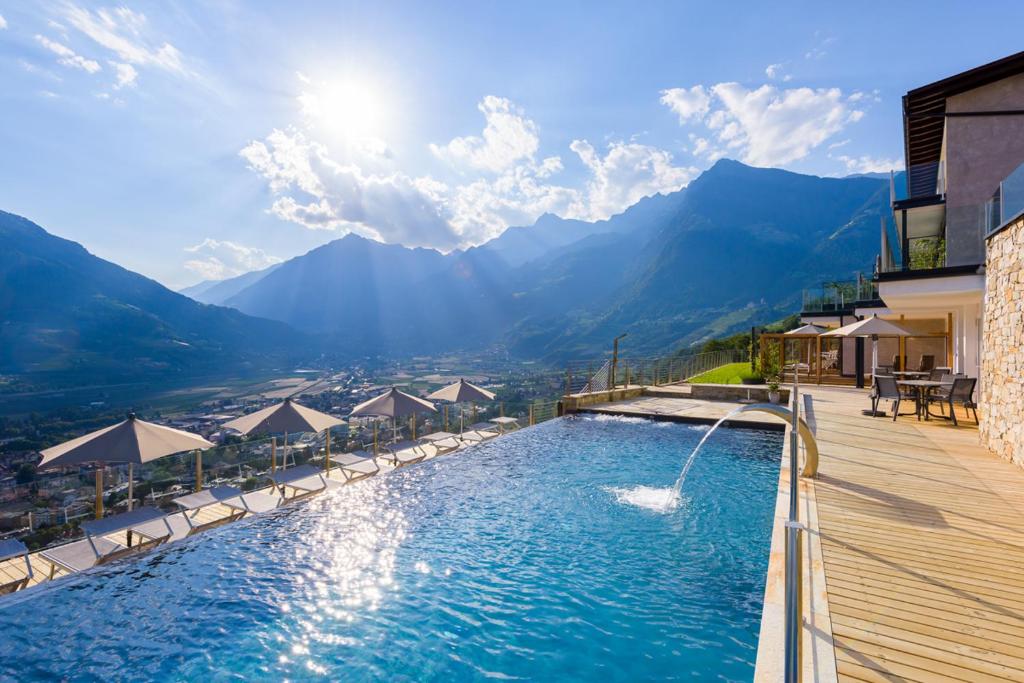 a swimming pool with a view of the mountains at La Pergola PanoramaSuites in Tirolo