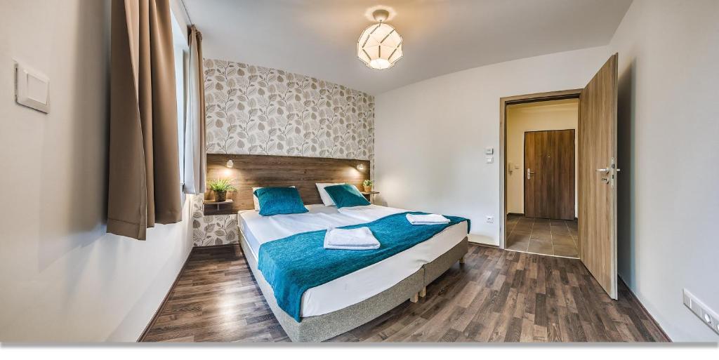 een slaapkamer met een groot bed met blauwe kussens bij Nova City Apartments in Boedapest