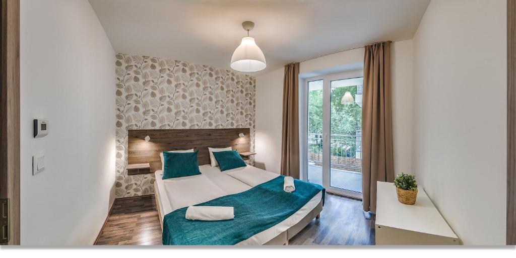 a bedroom with a large bed with blue pillows at Nova City Apartments in Budapest
