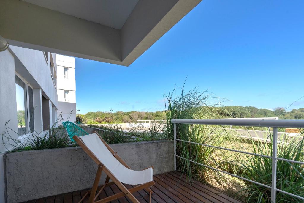 a chair on the balcony of a house at Valeria Playa Apart in Valeria del Mar