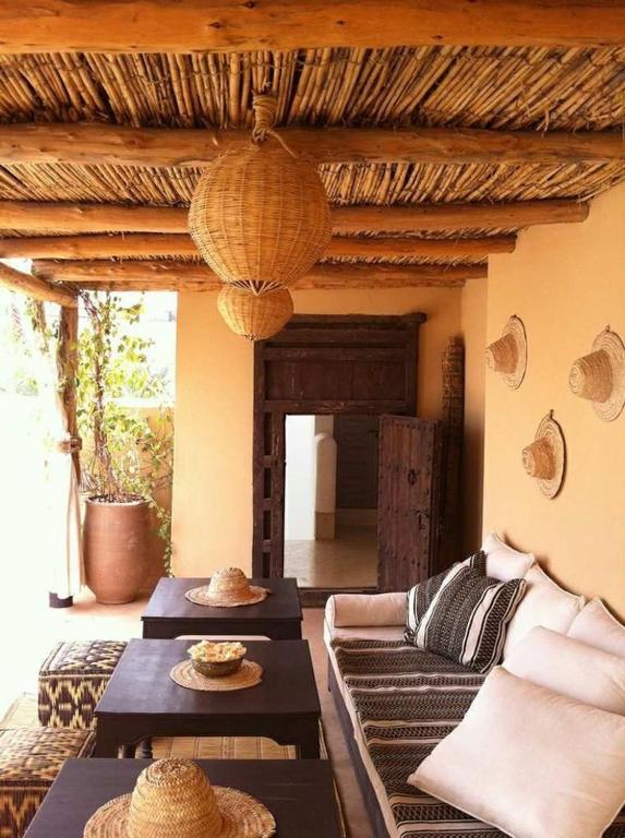a living room with couches and tables and a ceiling at Art house in El Jadida