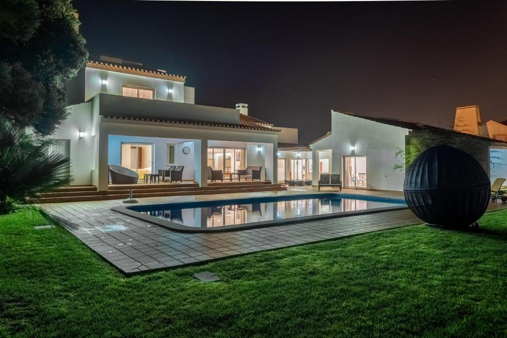 a villa with a swimming pool at night at Deslumbrante V6 in Casal da Lagoa Seca